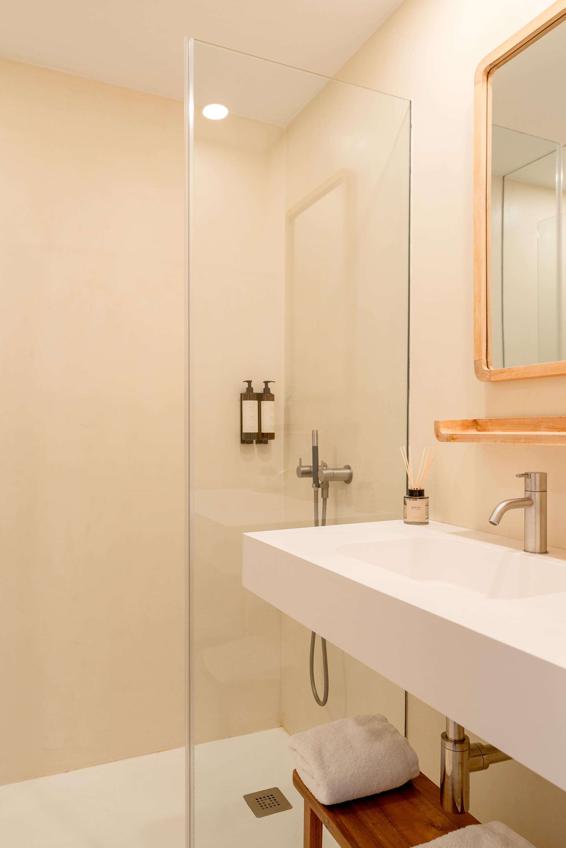 Bany de Norai amb dutxa, lavabo i mirall de fusta