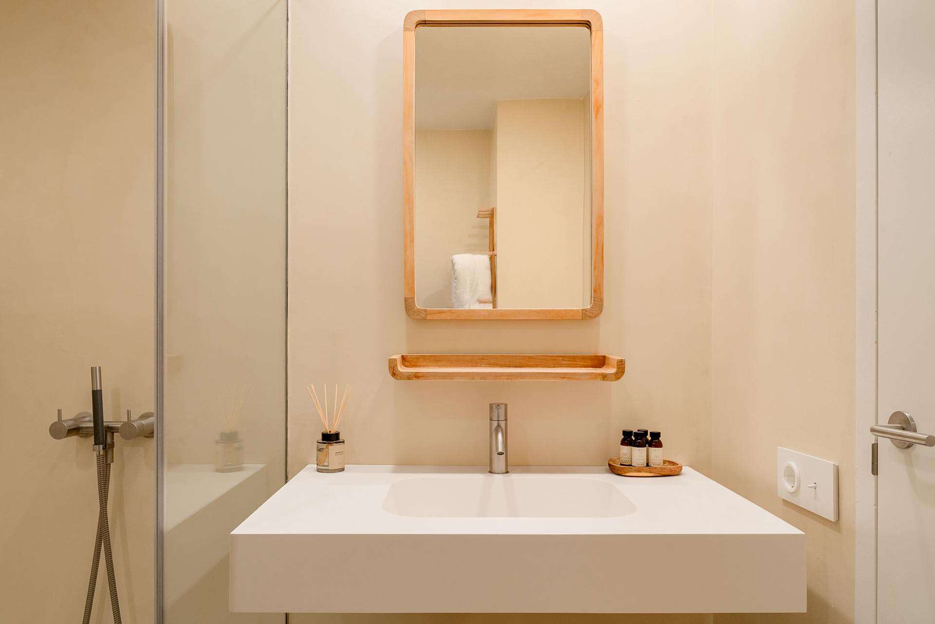 Bany de S'Arenella amb lavabo d'obra i mirall de fusta